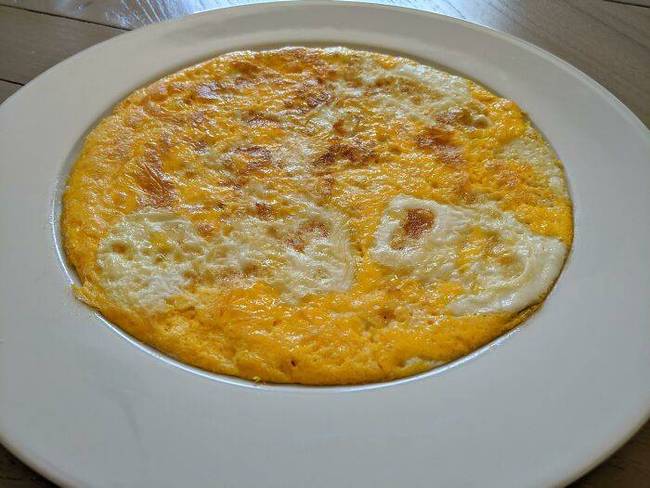 Egy omlett, ami tökéletesen passzol a tányérhoz, amiben felszolgálták.