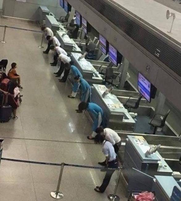 A repülőtér személyzete elnézést kér az utasoktól a járatkésések miatt.