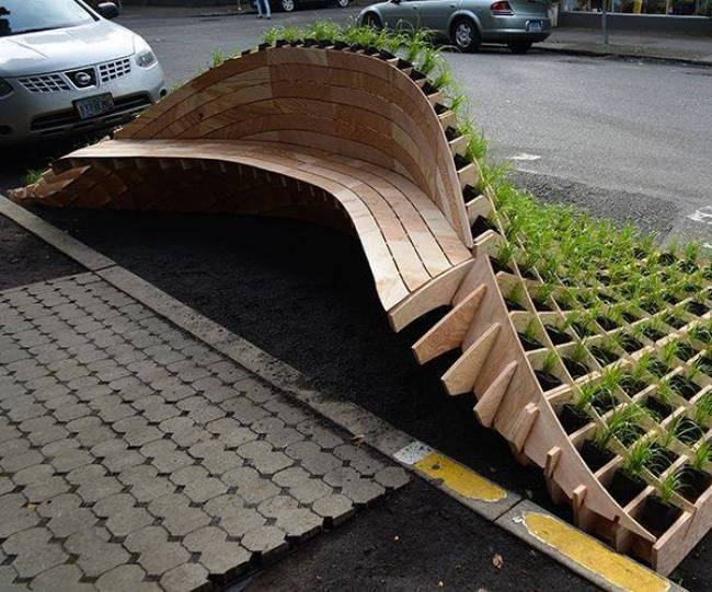Egy utcai pad, amely virágágyás is egyben.