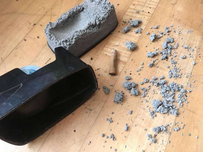 Ennek a ragasztószalag-adagolónak az aljában beton volt, ami mellett még egy cigarettacsikk is lapult.