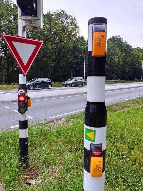 Ennél a holland átkelőhelynél külön gomb van a kerékpárral és a lóval érkező emberek számára.