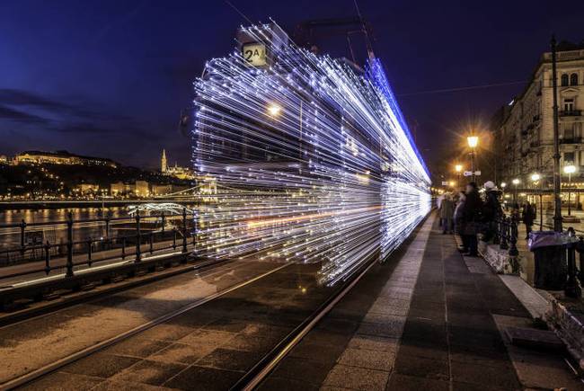 LED-fényekkel borított villamos Pesten, hosszú záridővel fényképezve.