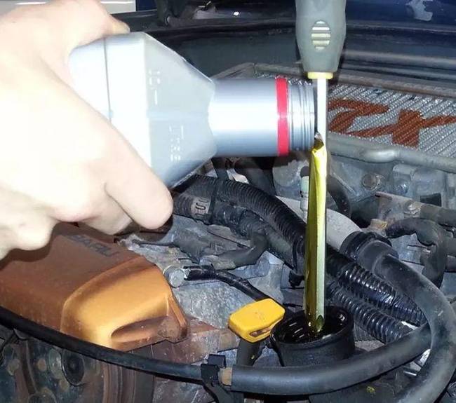 A lyuk fölé tartott csavarhúzó segít, hogy az olaj szépen egyenletesen csurogjon be a motorba.