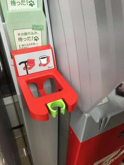 Sétabot és pohártartó egy japán bankautomata mellett.