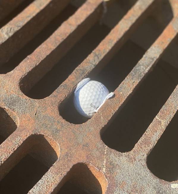 A golflabda tökéletesen beleolvadt a csatornarácsba.