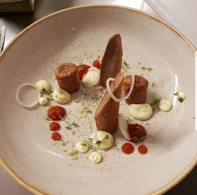 Szeletelt kolbász paradicsommártással, joghurtos öntettel és hagymával.