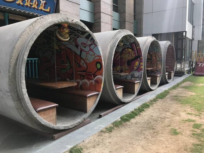 Egy étterem, ahol beton csatorna-elemekből alakították ki a fedett kerti részleget.