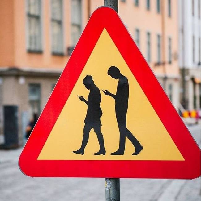 Stockholmban a közúti táblák figyelmeztetik az autósokat a telefonjukba bújt gyalogosokra.