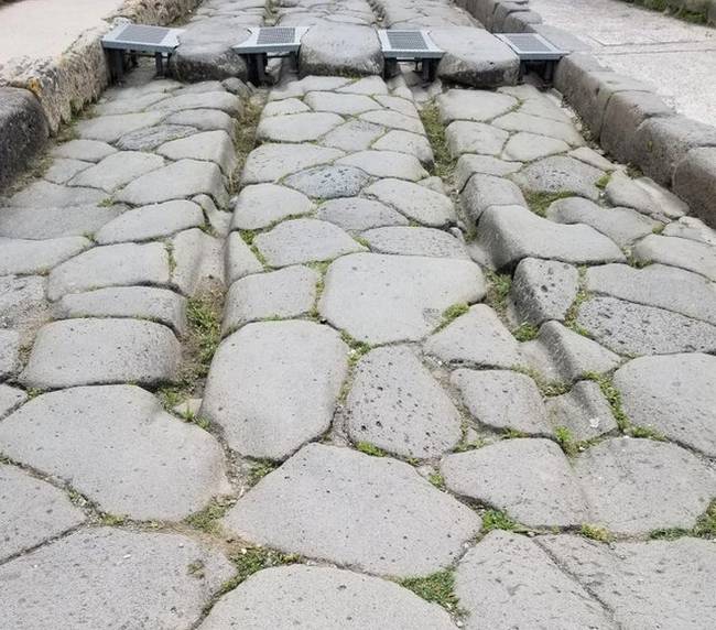 Több ezer lovaskocsi által hagyott nyom egy régi kőúton, Pompeiben.