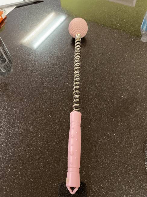 „Rózsaszín golflabda egy rugóra rögzítve. Mi lehet ez?