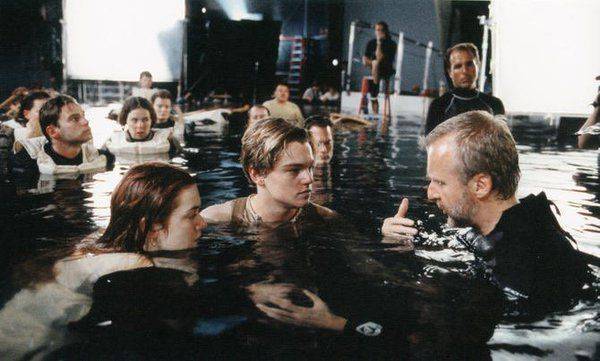 Leonardo DiCaprio és Kate Winslet, amint James Cameron tanácsait hallgatják a Titanic című film forgatásán.