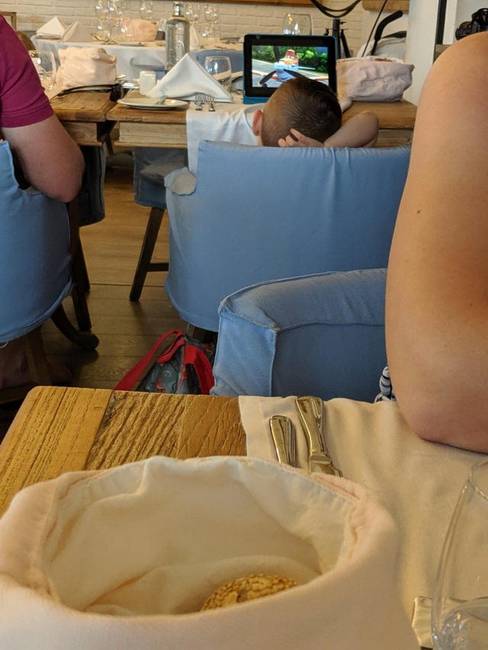 „A gyermek teljes hangerőn nézte a mesefilmet, miközben vacsoráztunk a feleségemmel."
