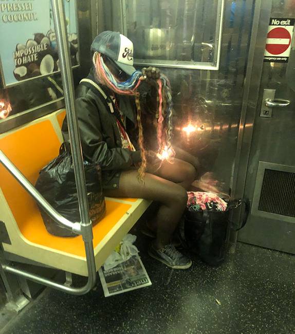 Ez a nő a metróban égeti a haját egy öngyújtóval.