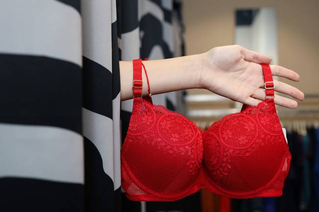 A girl shows underwear from the fitting room. Selection process