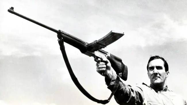 Harry Togerson hadnagy, az Amerikai Tengerészgyalogság tisztje egy kísérleti M1941 Johnson géppuskával lő egy teszt során New Riverben (Észak-Karolina), 1942 elején. Közkincs, az Amerikai Tengerészgyalogság fotója (The Armory Life).
