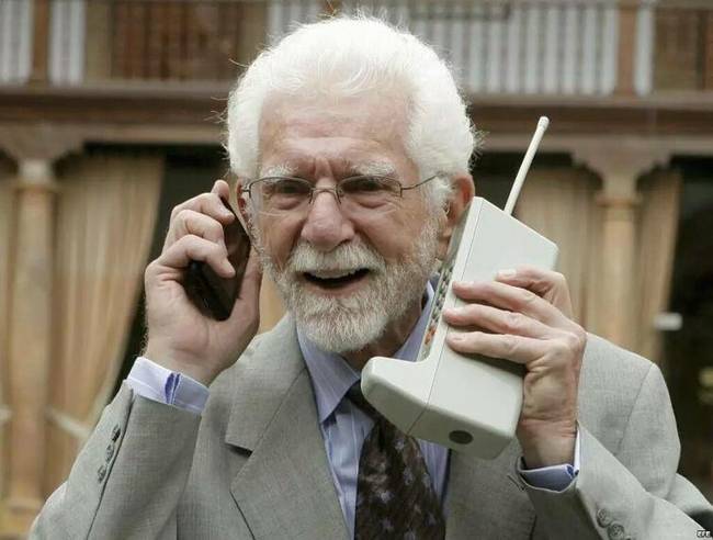 Az első kereskedelmi forgalomban kapható mobiltelefon megalkotója, Martin Cooper a találmányával, és egy ma használatos telefonnal a kezében.