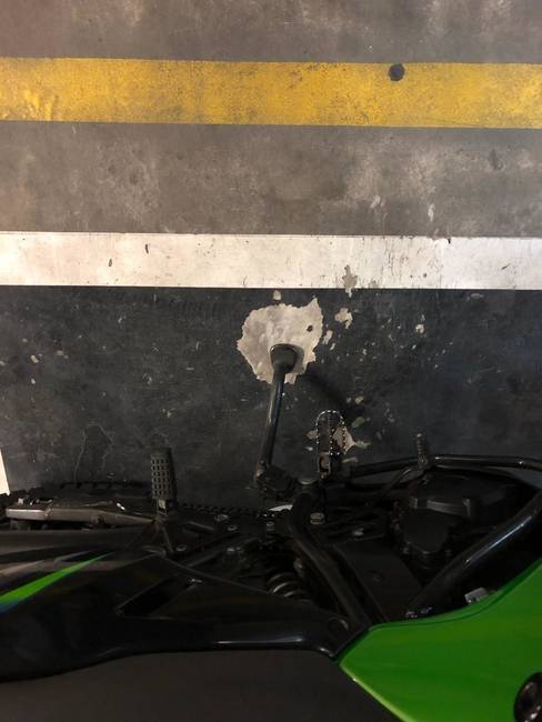 Egy motoros parkolóhely, aminél túlnyomó többségben ugyanott teszik le a kitámasztót a motorosok.